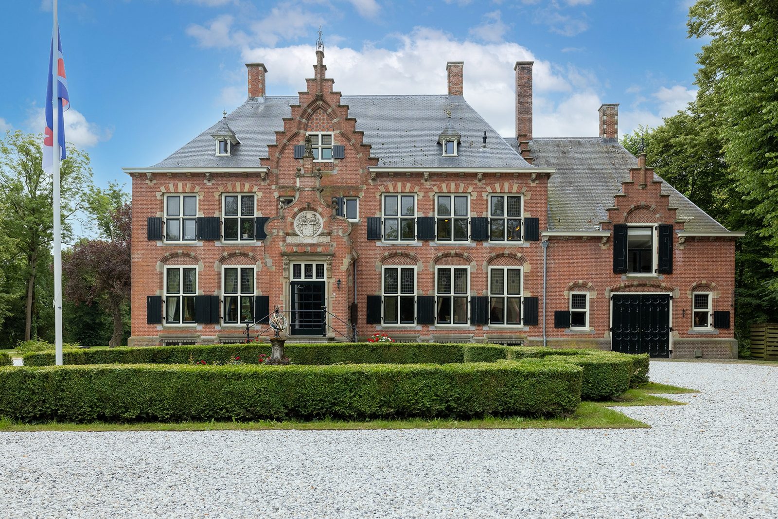 baksteen landhuis met trapgevels en lage hagen voor een grindplein in Ysbrechtum